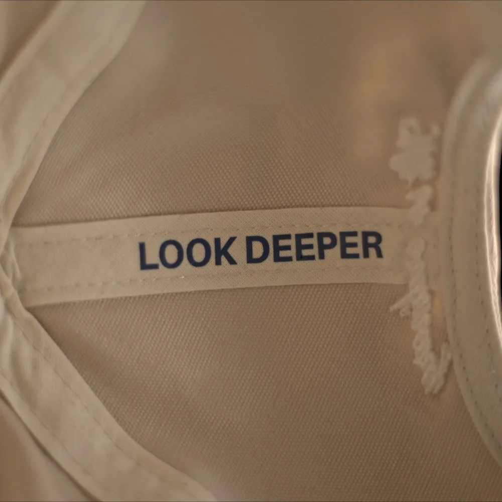 Nastro sbieco interno con la scritta Look deeper